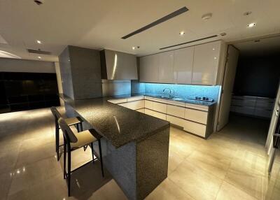 Modern kitchen with bar counter and overhead lighting