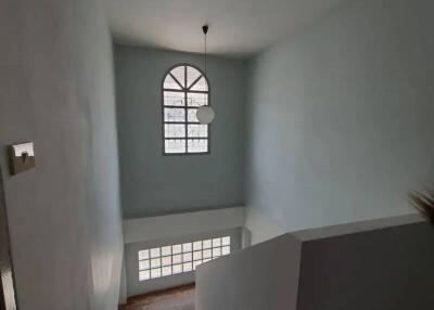 Stairway with large windows and a pendant light