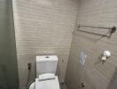 Modern bathroom with beige tiling and high-tech toilet