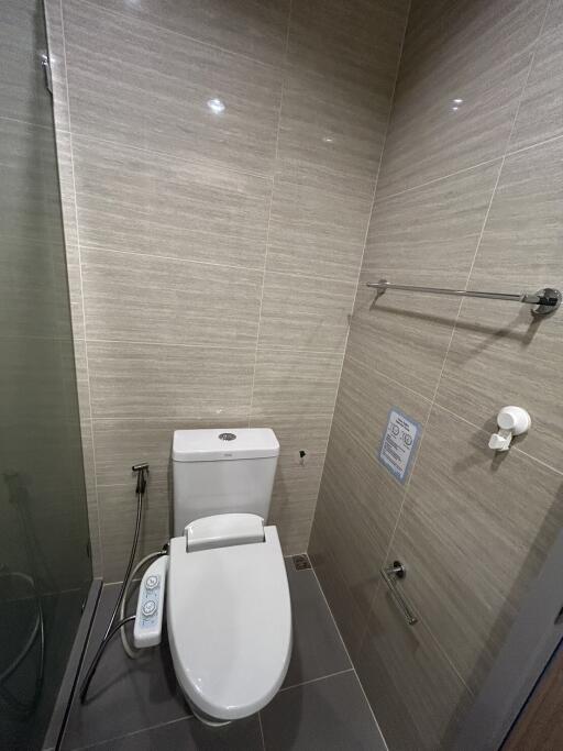 Modern bathroom with beige tiling and high-tech toilet