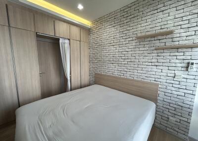 Modern bedroom with built-in wardrobe and brick accent wall