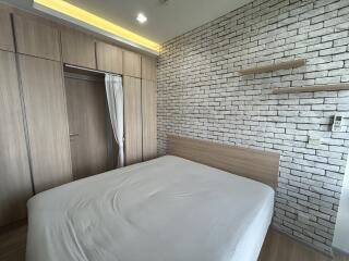 Modern bedroom with built-in wardrobe and brick accent wall