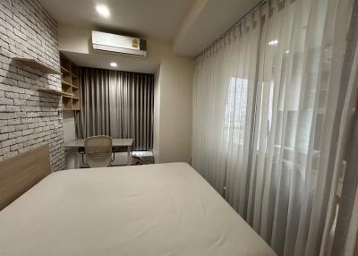 Bedroom with study area, air conditioning, and large windows