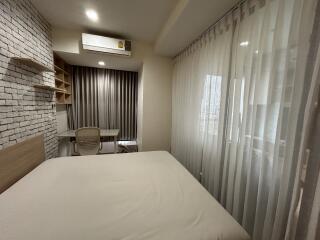 Bedroom with study area, air conditioning, and large windows