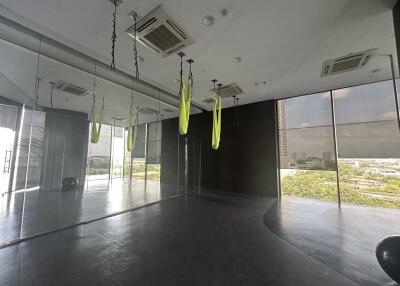 Modern fitness studio with aerial yoga equipment and large windows