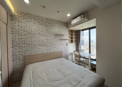 Modern bedroom with brick accent wall and large window