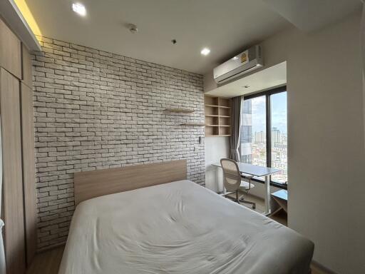 Modern bedroom with brick accent wall and large window
