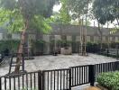 Gated outdoor area with trees and benches