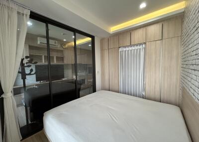 Modern bedroom with large bed, mirrored closet doors, and wood paneling