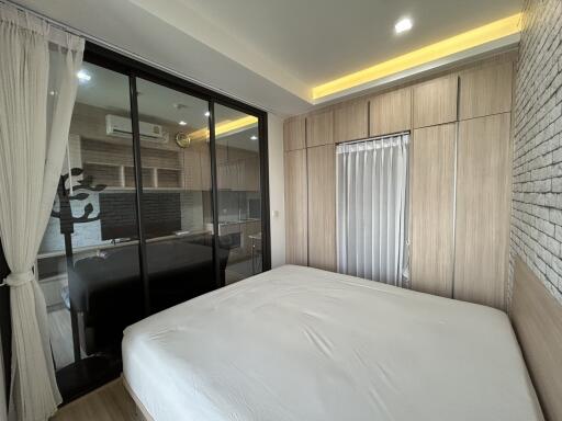 Modern bedroom with large bed, mirrored closet doors, and wood paneling