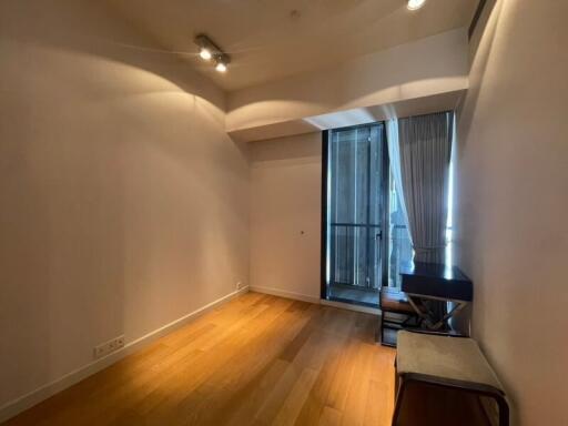 Empty living room with wooden flooring and balcony access