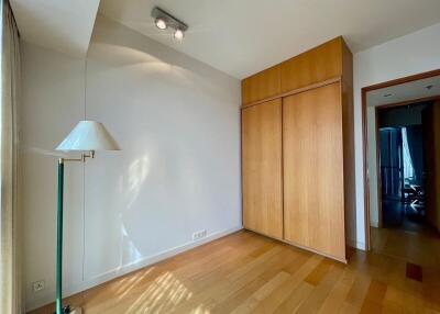 Small bedroom with wooden floor and built-in wooden wardrobe