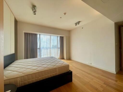 Spacious bedroom with a large window and natural light