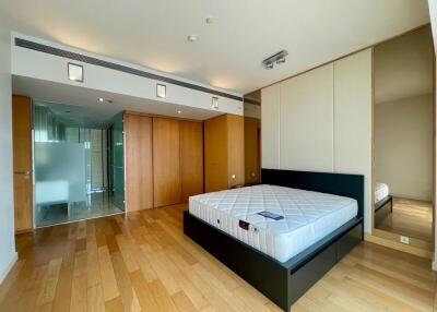 Spacious modern bedroom with wooden flooring and large bed