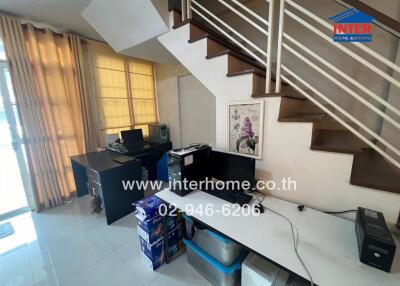 Living space under staircase with desks and computer setups