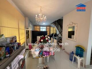 Living room with chandelier, mirror, and staircase