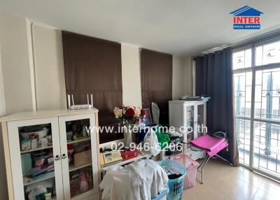 Cluttered bedroom with storage cabinets and a large window