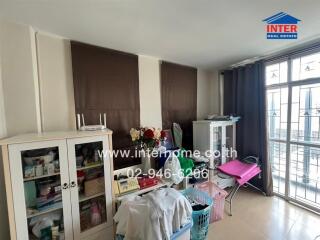 Cluttered bedroom with storage cabinets and a large window