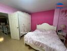 Bedroom with pink walls, white wardrobe, and double bed