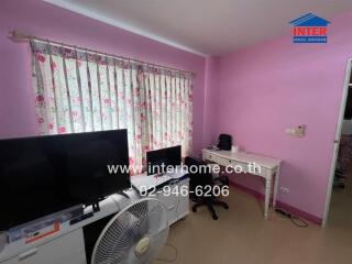 Bedroom with pink walls and a desk