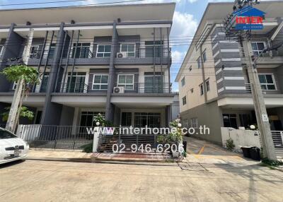 Modern townhouses with balconies and a small front yard