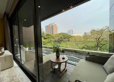 Modern balcony with glass railing overlooking a green area and cityscape