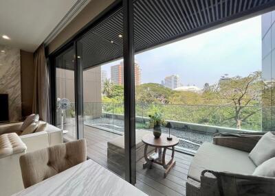 Modern living room with large glass doors leading to a balcony with outdoor seating
