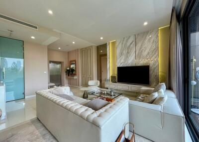 Modern living room with a large TV and ample seating