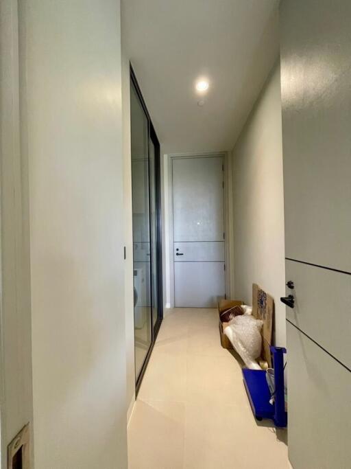 Narrow hallway with a closed door and glass-paneled locker