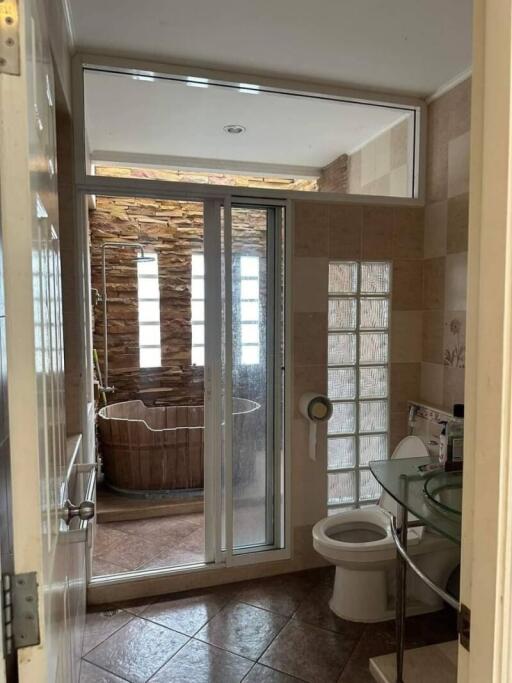 Modern bathroom with glass door and freestanding tub in the background