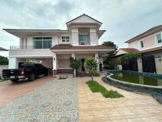 Exterior view of a two-story house with a driveway, garage, and a small pool in the yard