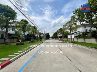 A view of the neighborhood with houses, trees, and a wide street