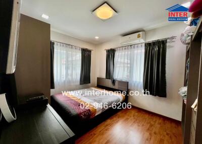 Bedroom with large windows and wooden floor