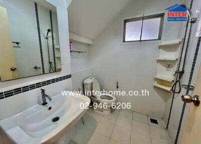 Bathroom with sink, toilet, mirror, and shower area