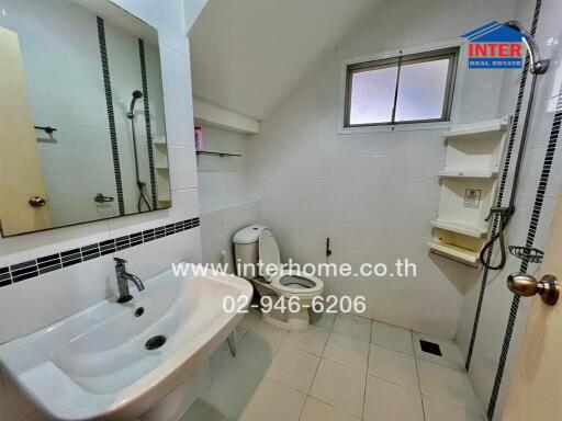 Bathroom with sink, toilet, mirror, and shower area