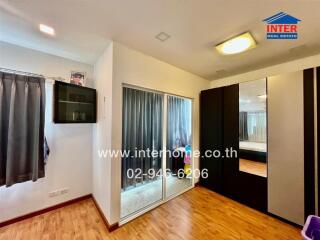 Spacious bedroom with hardwood flooring, built-in closet, and large mirror doors