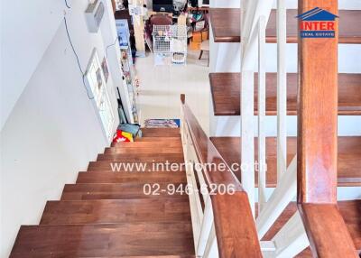 Interior staircase with wooden steps and white railings