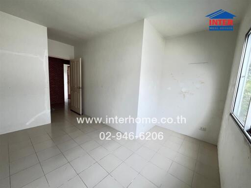 Empty bedroom with tiled floor and a single window