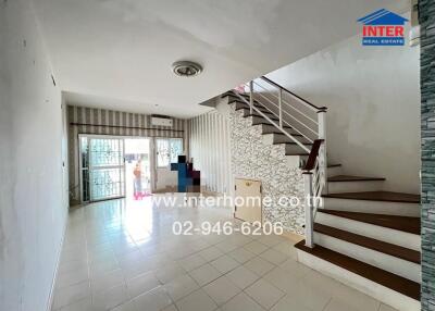 Spacious living area with staircase and large window