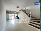 Spacious living area with staircase and large window