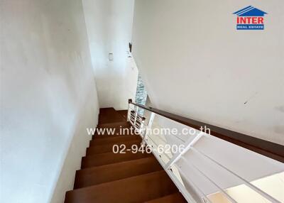 Staircase with wooden steps and white handrail
