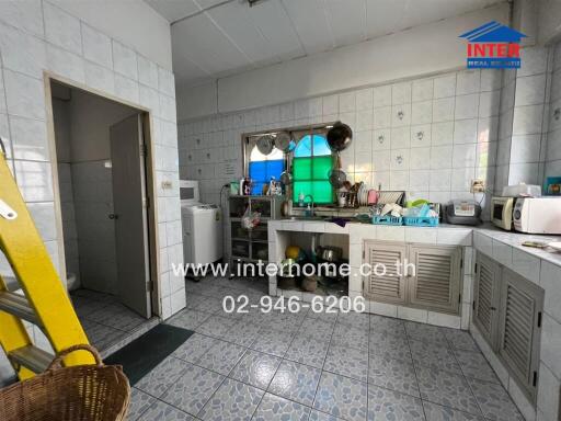 A well-used kitchen with various appliances and a unique tiled floor.