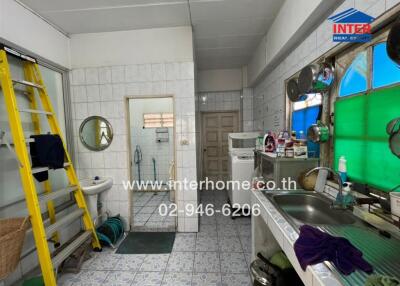 Spacious kitchen with large sink, storage shelves, and a washing machine