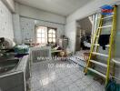 A kitchen with tiled walls and floors, featuring a sink, countertop, and storage cabinets