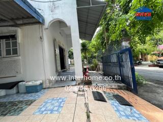 Exterior view of a residential building with tiled driveway and gated entrance