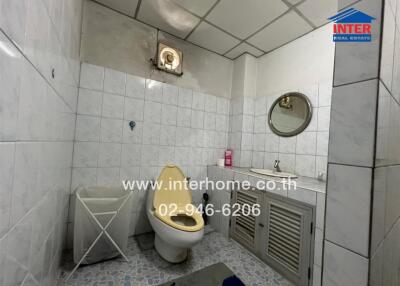 Bathroom with white tiles, sink, mirror, and a toilet