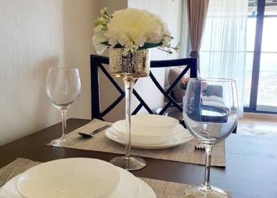 Elegant dining setup with white plates, wine glasses, and decorative flower vase