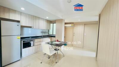 Modern kitchen with sleek cabinets, dining area, and stainless steel appliances