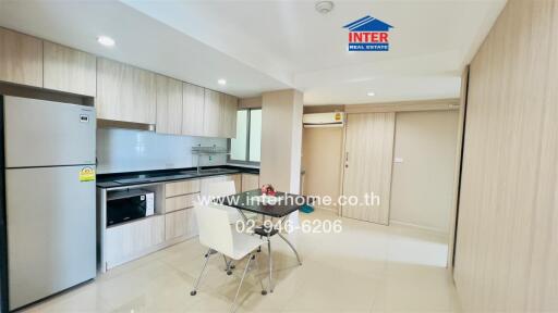 Modern kitchen with sleek cabinets, dining area, and stainless steel appliances