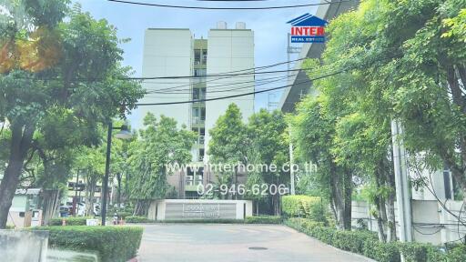 Exterior view of an apartment building with lush greenery